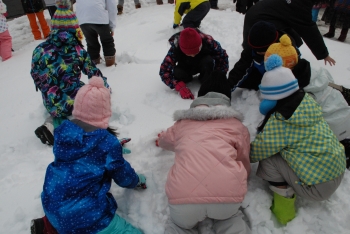 写真:雪の中に隠されたスーパーボールを探すこどもたち