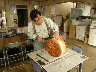 写真：ケーキ作りのためにパンを切っている様子