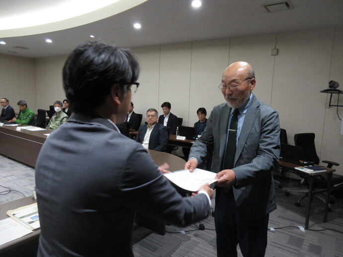 写真：神田会長へ諮問書を手渡す市民環境部長